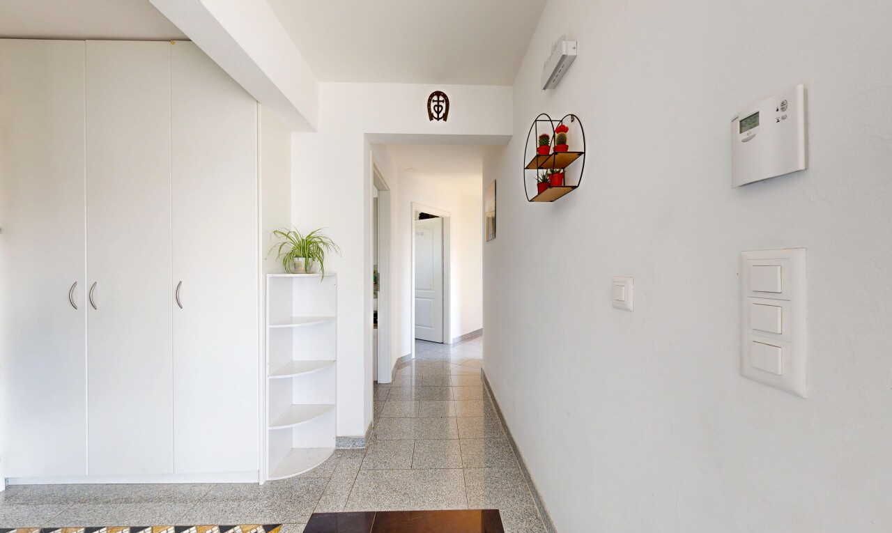 couloir avec plinthes murales, baseboards wall, light floor, cloison sèche, et drywall