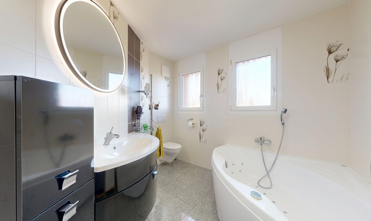 salle de bains avec toilette, miroir, lavabo (ou coiffeuse selon le contexte), light floor, et lumière naturelle