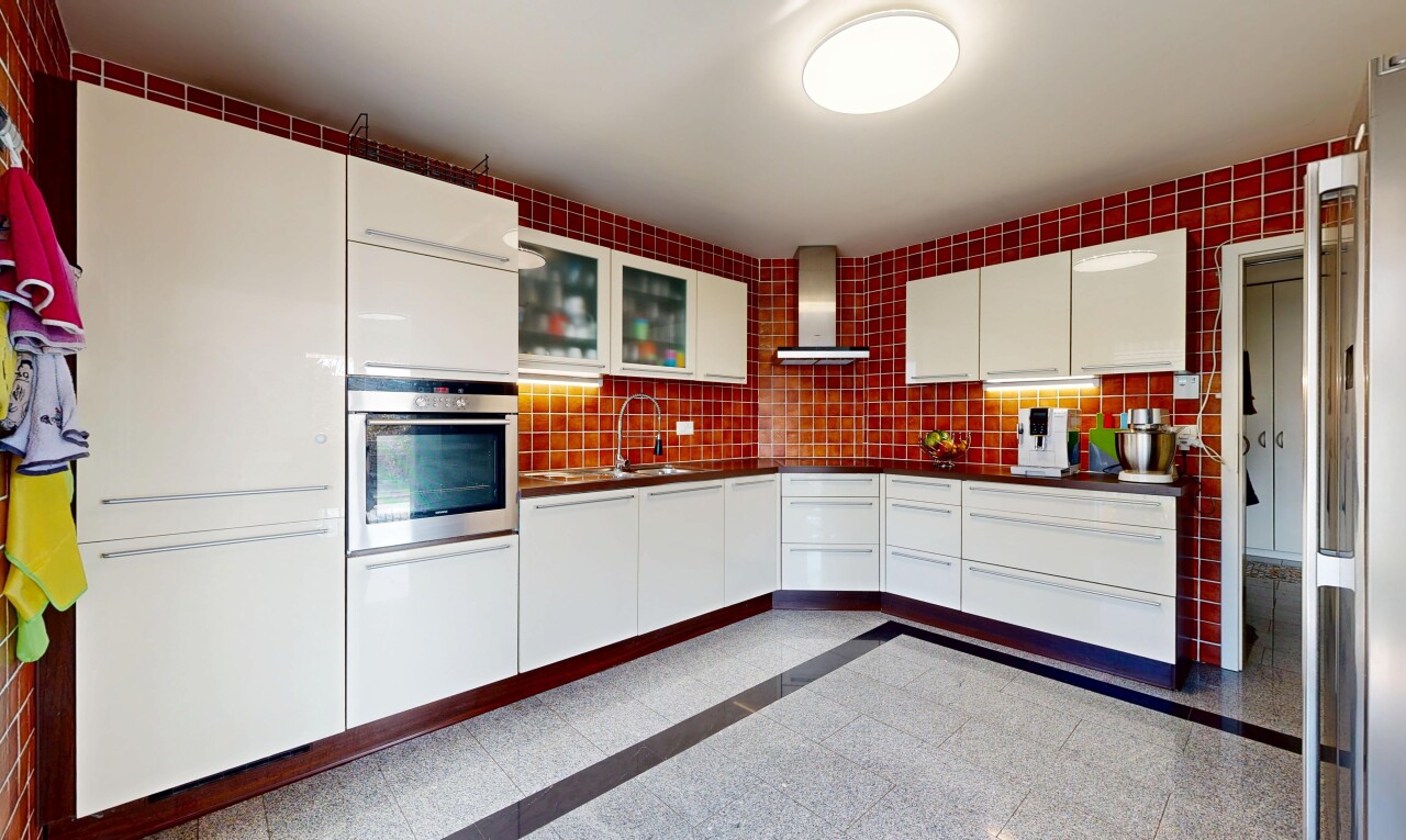 cuisine avec four, hotte, armoires avec insert en verre, glass insert cabinets, et sol en finition granit