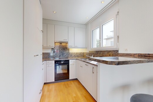 küche mit two heights countertops, ofen, light floor, dark countertops, und white cabinets