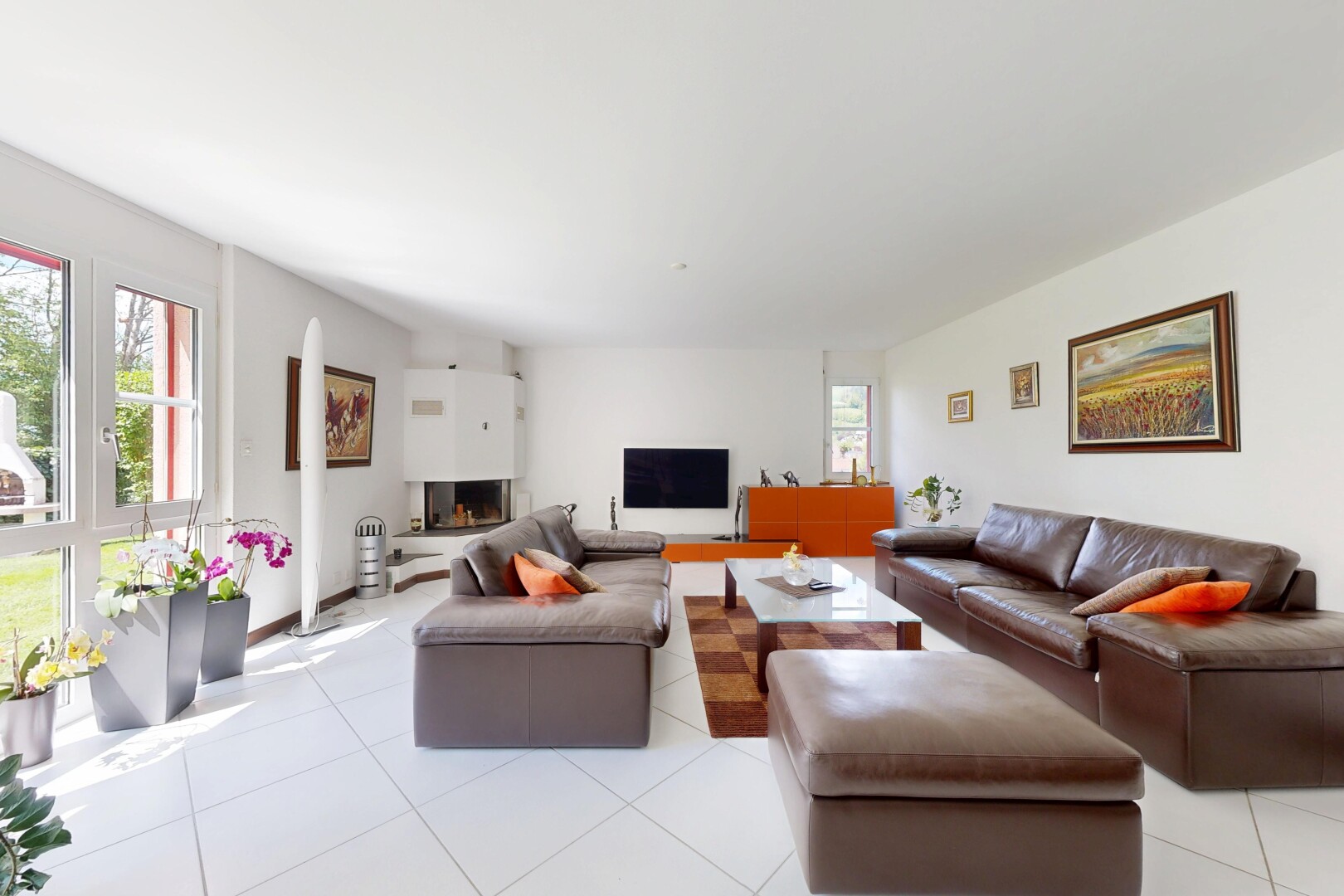 living room featuring light tile patterned floors and a warm lit fireplace