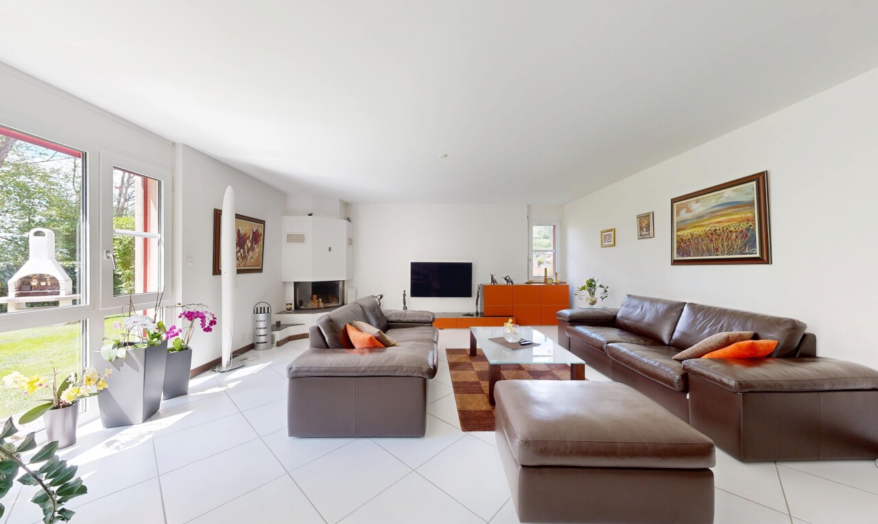 living room featuring light tile patterned floors and a warm lit fireplace
