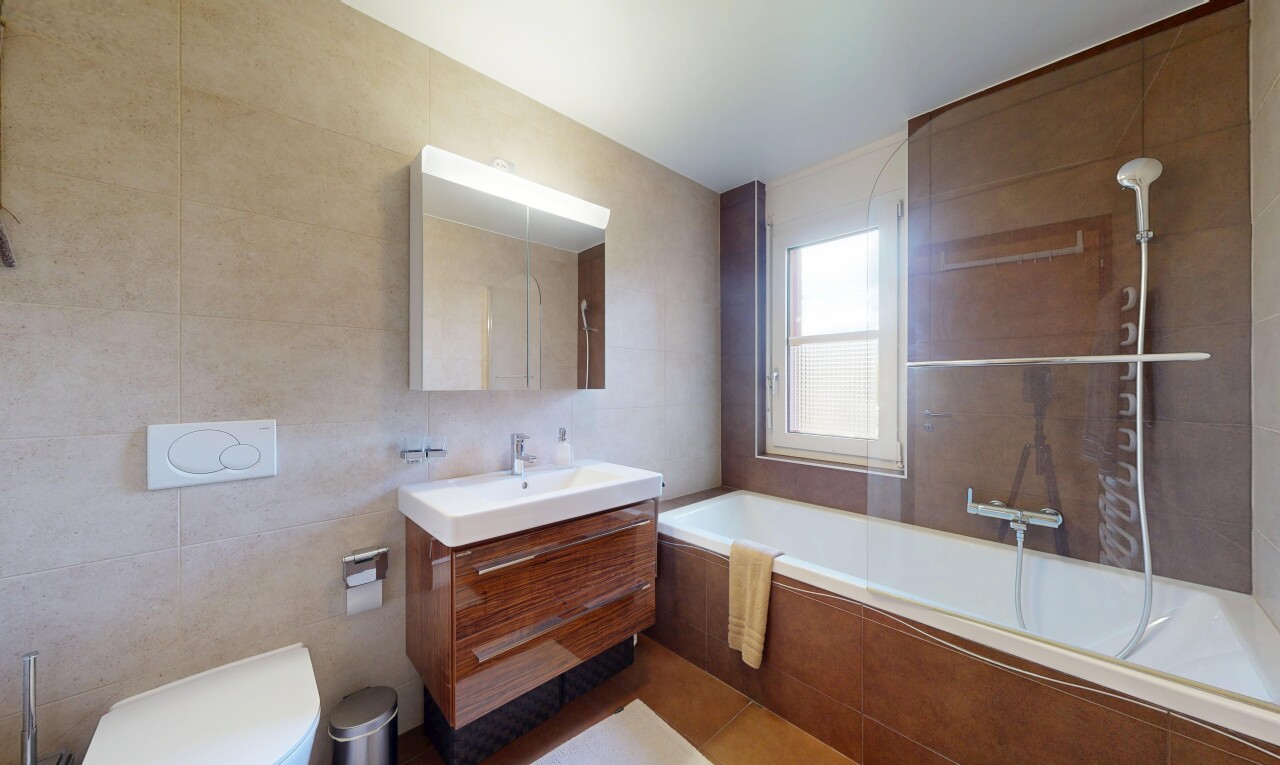 full bath with tile walls, vanity, and tiled shower / bath