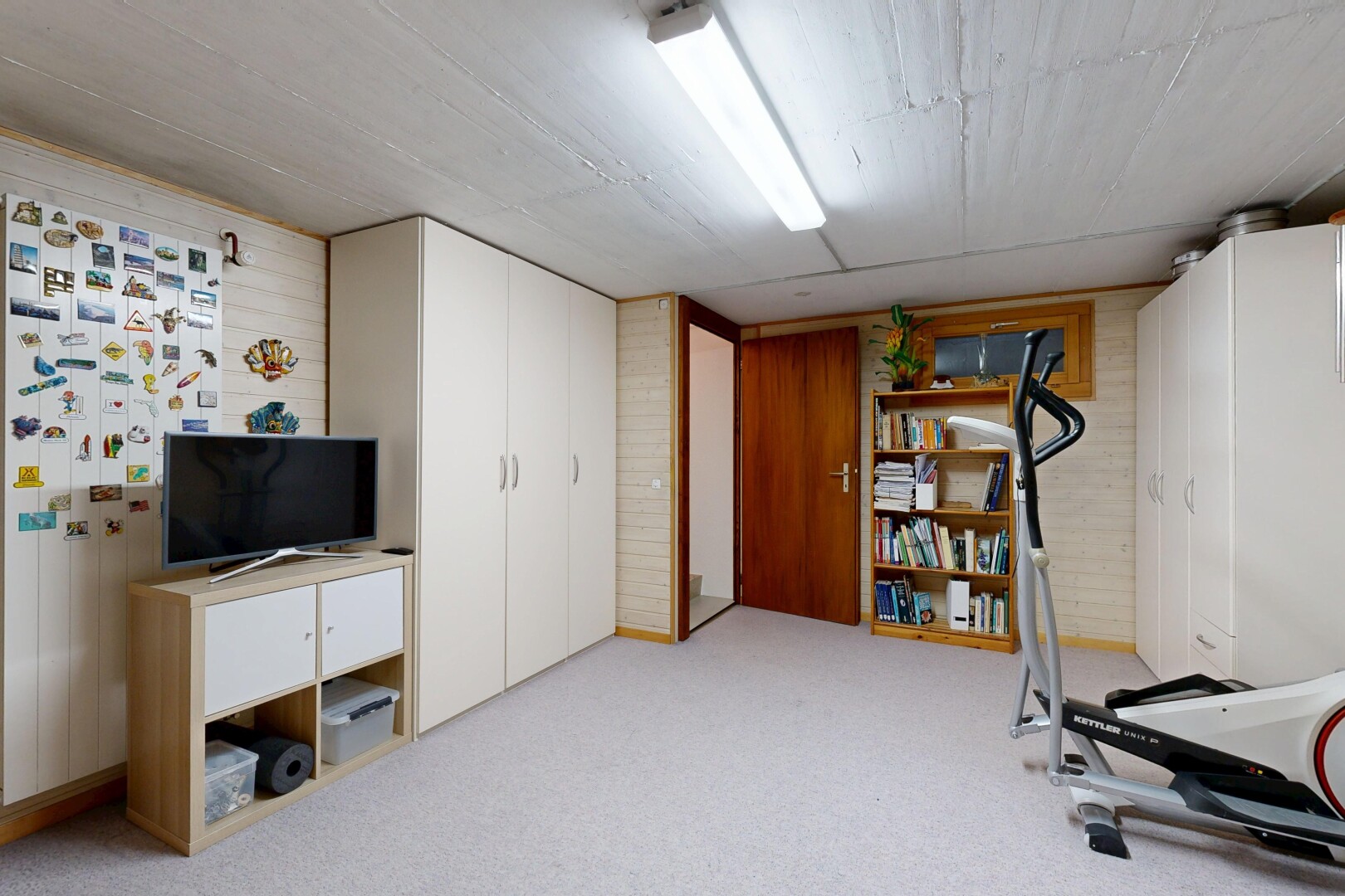 gym avec low ceiling, plafond bas, wood wall, mur en bois, et inside property