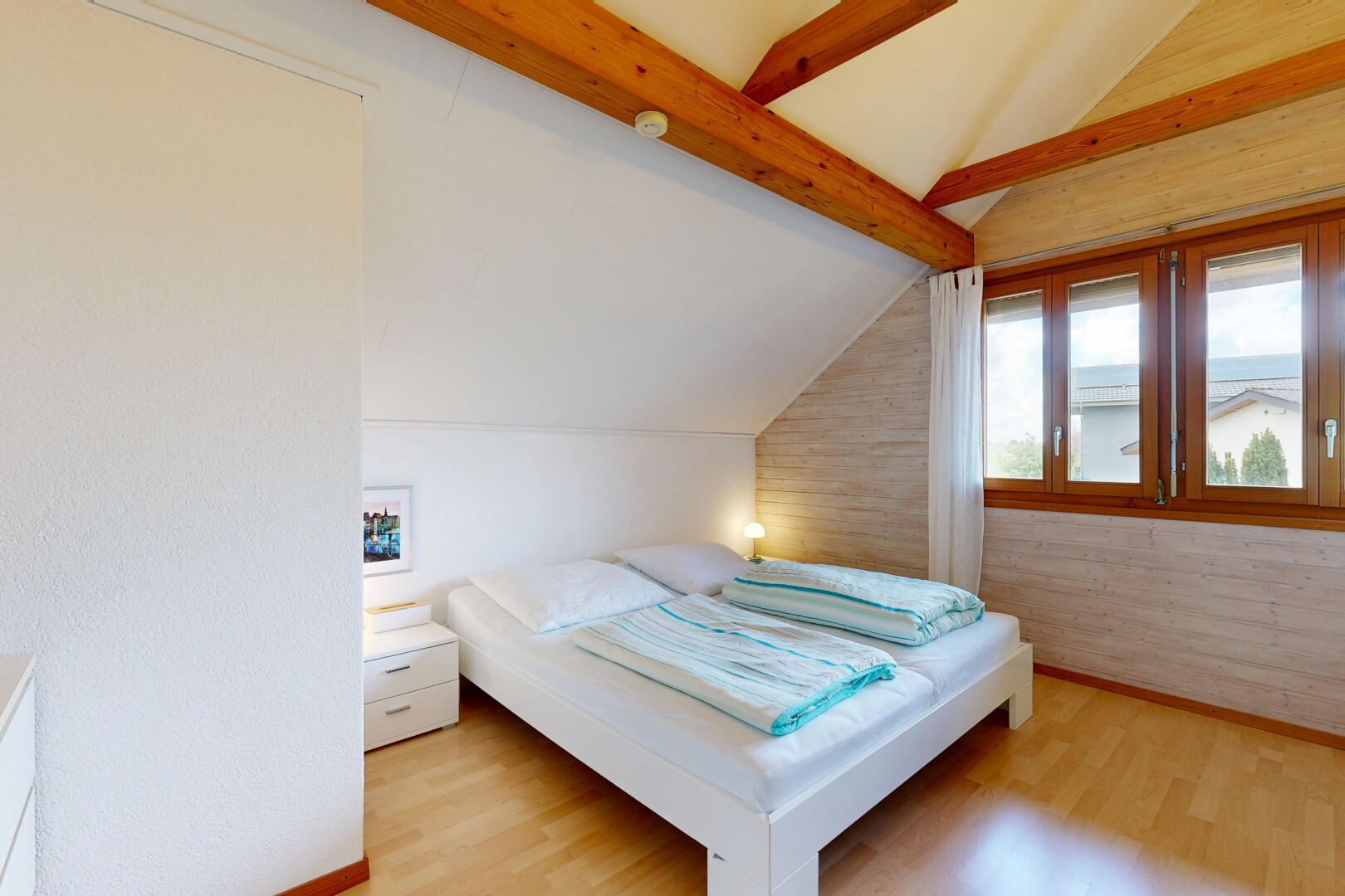 chambre avec plafond voûté, vaulted ceiling, inside property, sol en finition bois, et wood finish floor