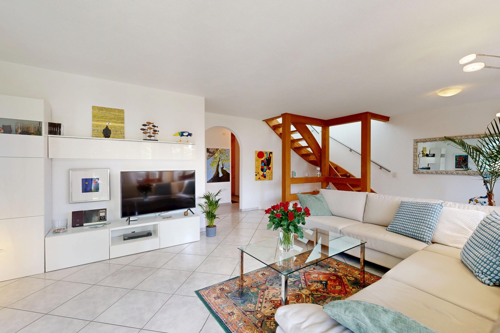 salon avec télévision, inside property, cloison sèche, drywall, et passages en arc