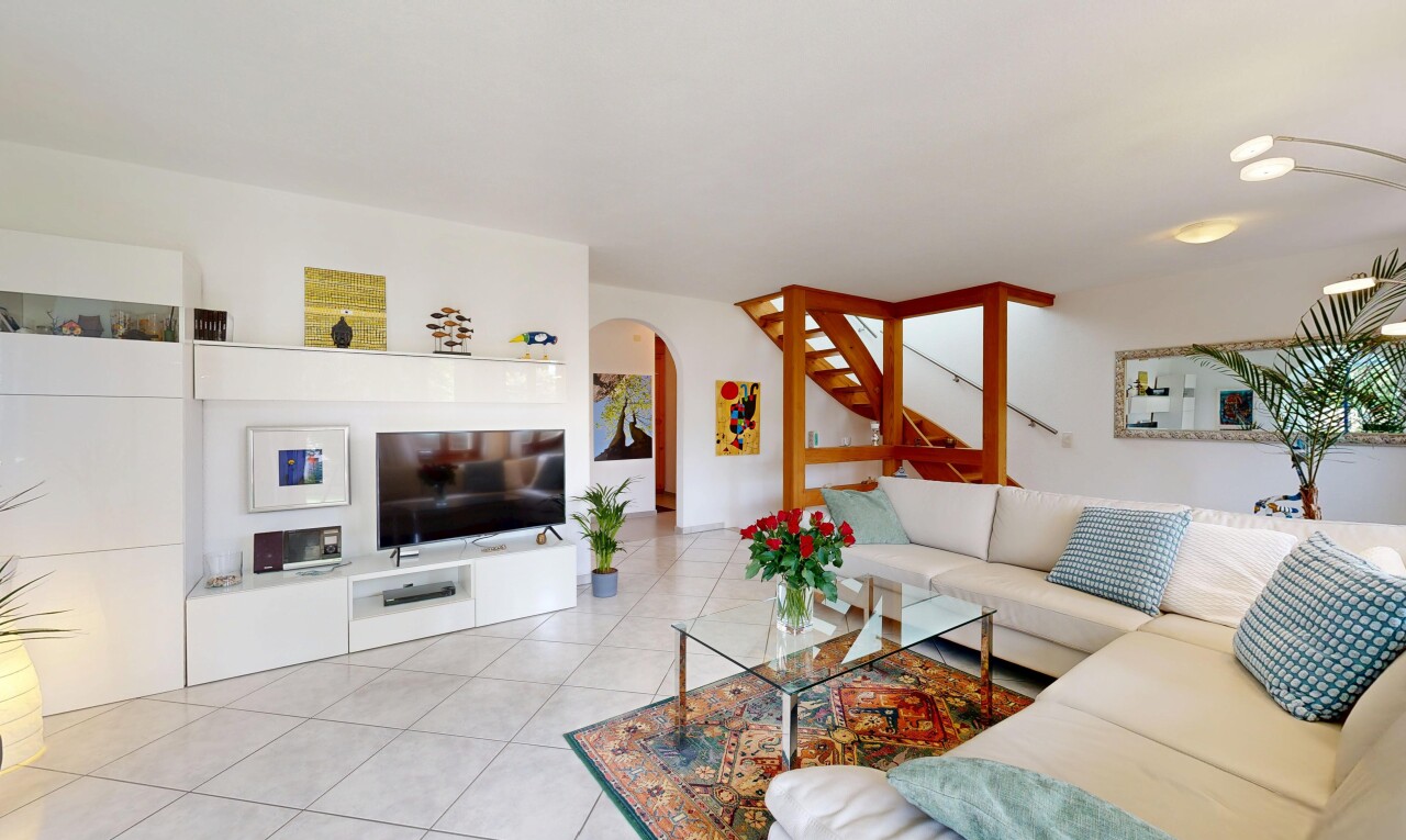 salon avec télévision, inside property, cloison sèche, drywall, et passages en arc