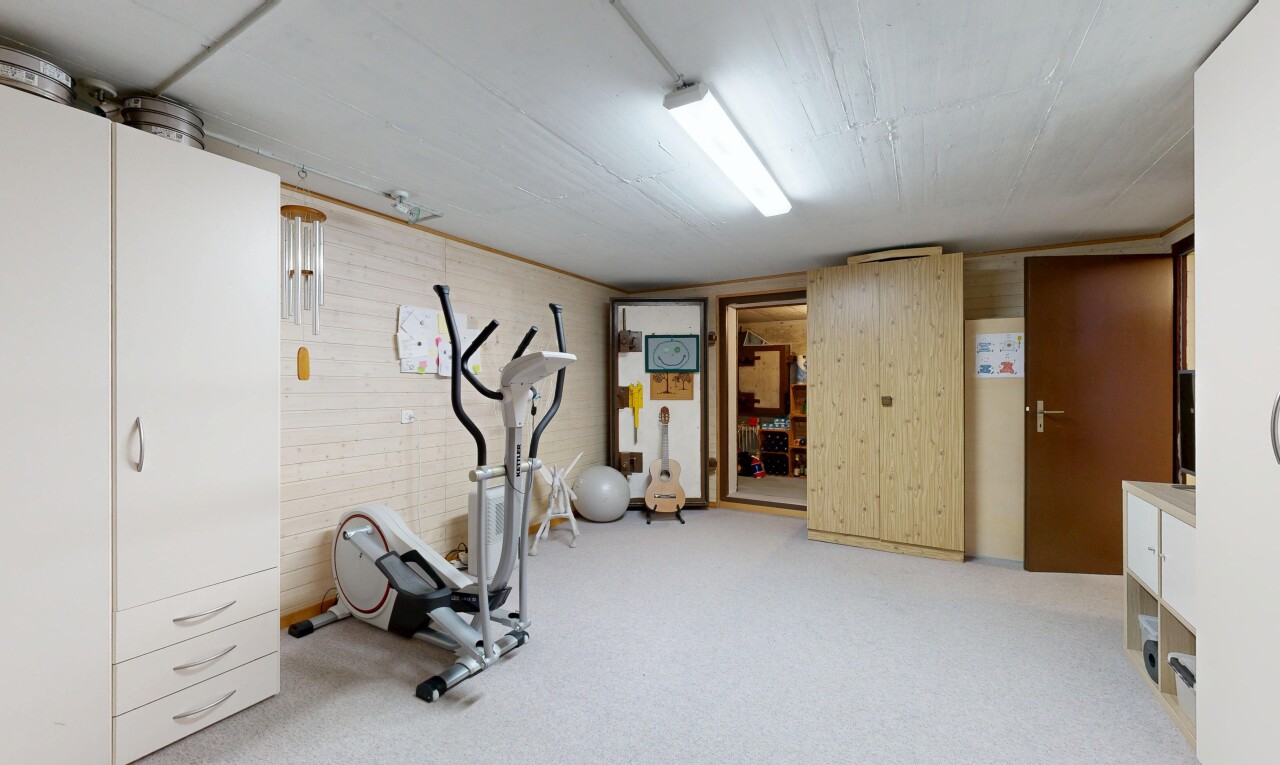 gym avec plafond bas, low ceiling, inside property, sous-sol, et mur en bois