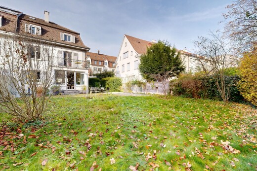 view of property with a yard, a chimney, and a balcony
