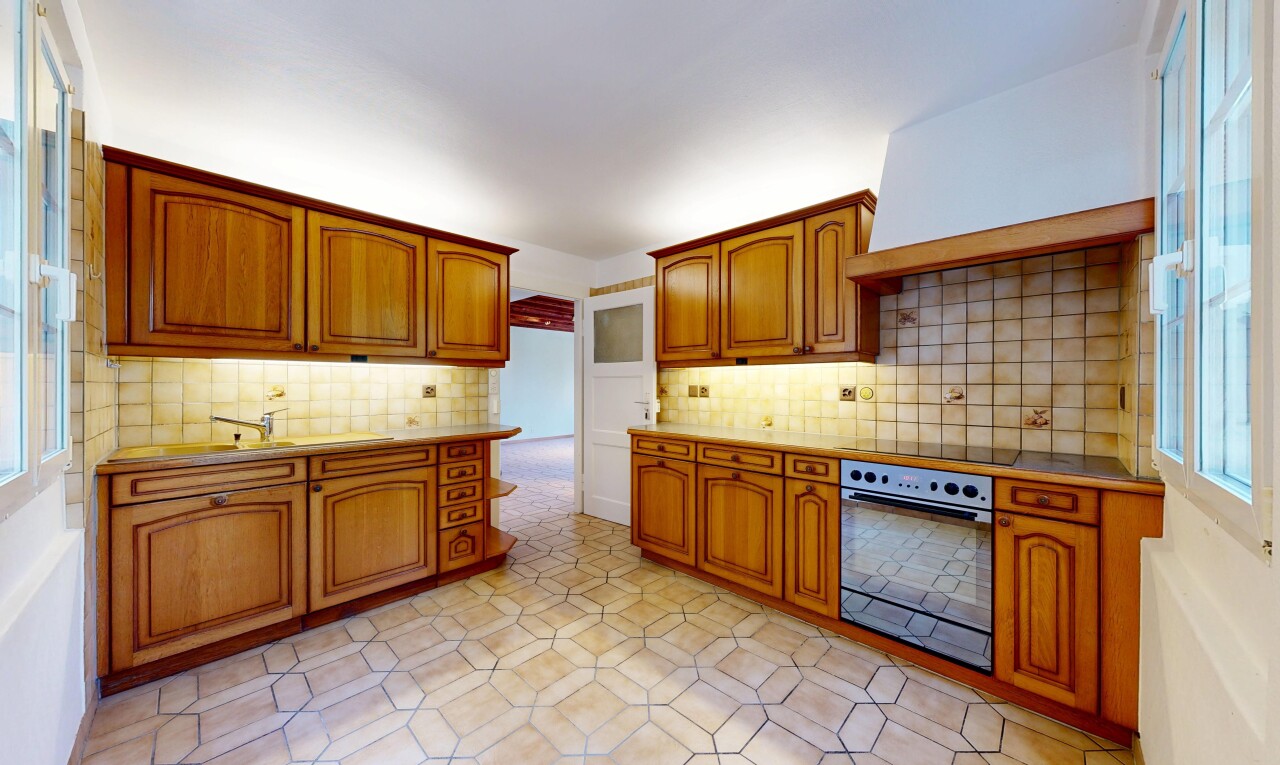 cuisine avec arched cabinets, armoires en arc, four, light floor, et medium brown cabinets
