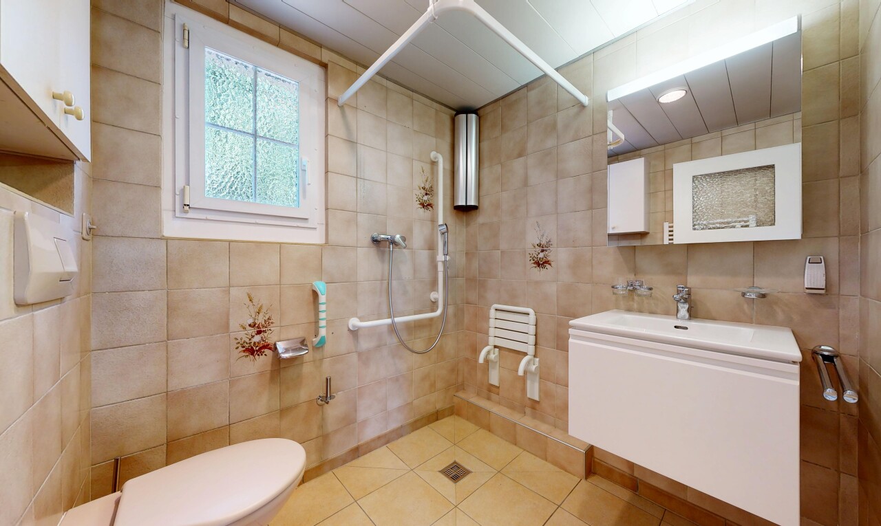 salle de bains avec lavabo (ou coiffeuse selon le contexte), toilette, miroir, inside property, et mur en carrelage