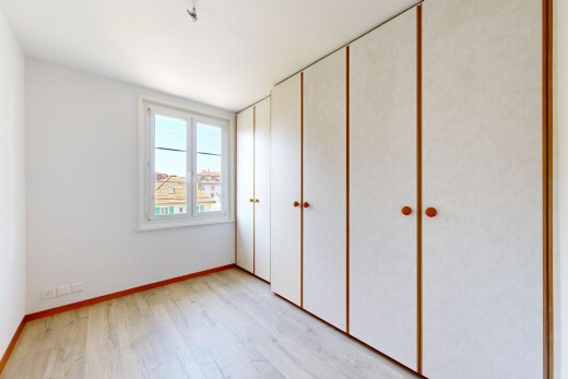 zimmer / schlafzimmer mit day time, light floor, holzfußboden, wood finish floor, und kleiderschrank