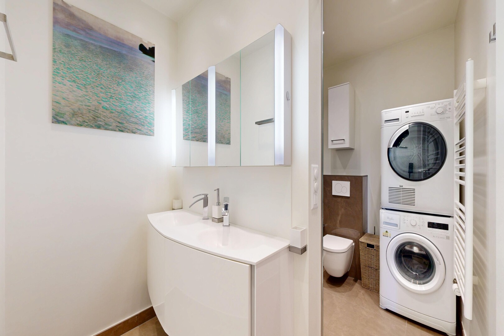 full bath with a towel warmer, stacked washer / dryer, and vanity