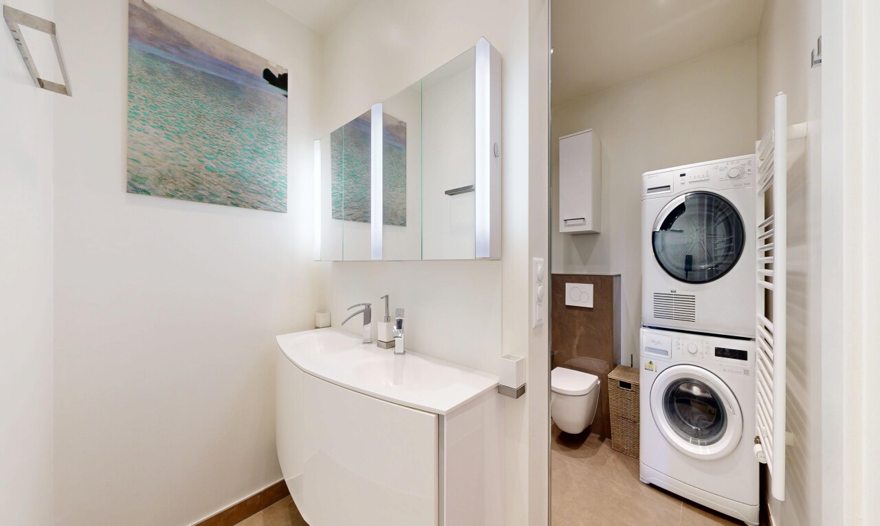 full bath with a towel warmer, stacked washer / dryer, and vanity