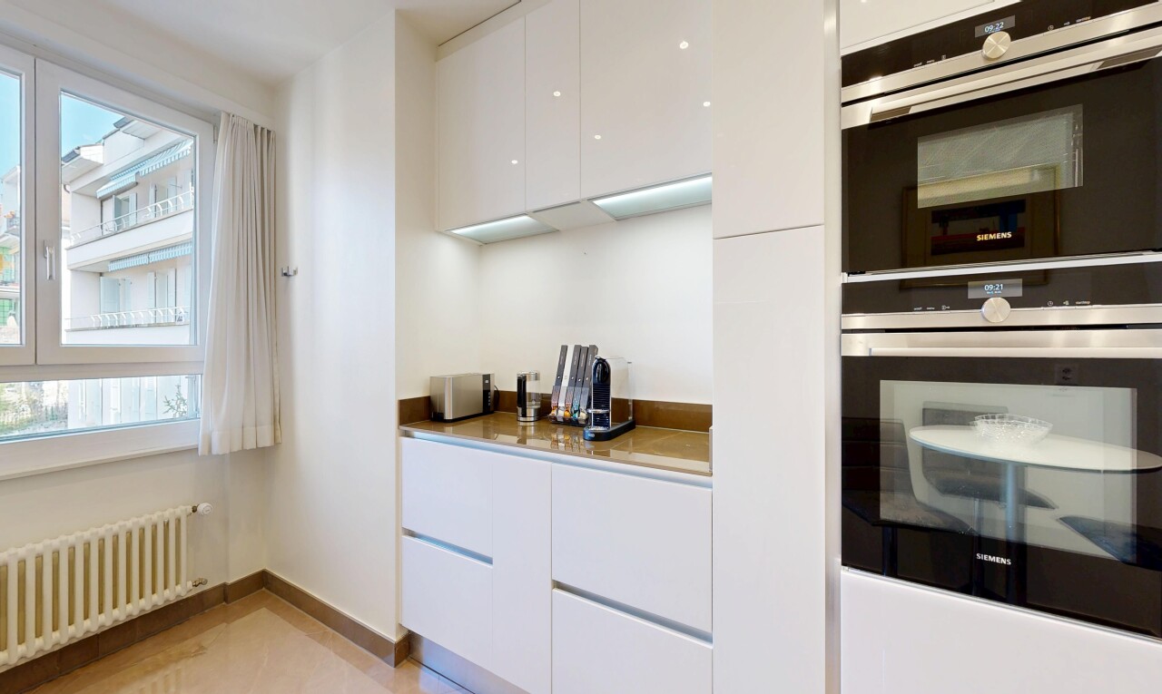kitchen with modern cabinets, double oven, white cabinetry, and radiator heating unit