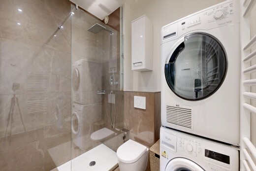 salle de bains avec salle de bain complète, lave-linge et sèche-linge superposés, douche, inside property, et tile wall