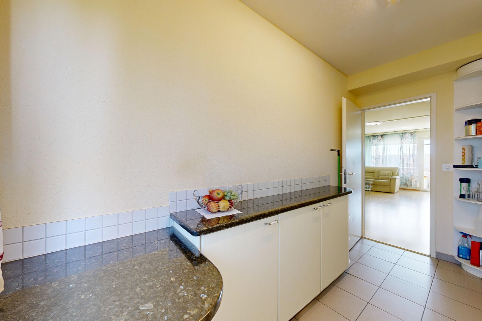 cuisine avec dark countertops, armoires blanches, white cabinets, inside property, et light floor
