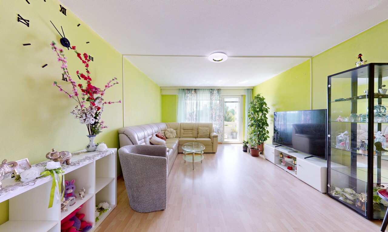 salon avec cloison sèche, drywall, sol en finition bois, wood finish floor, et lumière naturelle