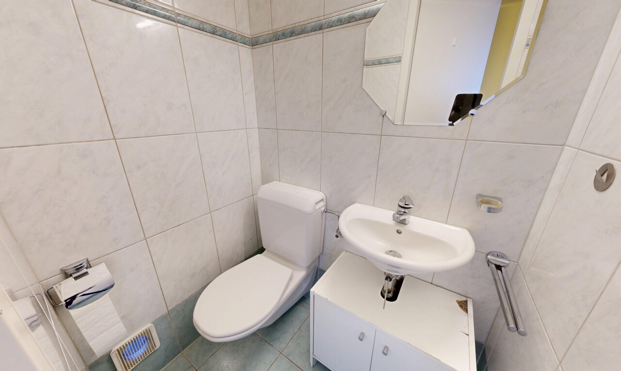salle de bains avec tile wall, mur en carrelage, toilette, miroir, et inside property