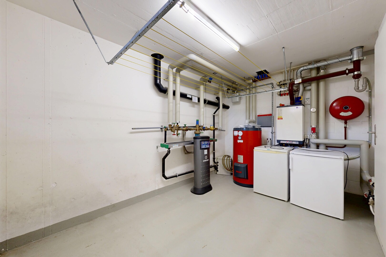 buanderie avec sol en béton, concrete floor, cloison sèche, drywall, et lave-linge et sèche-linge séparés