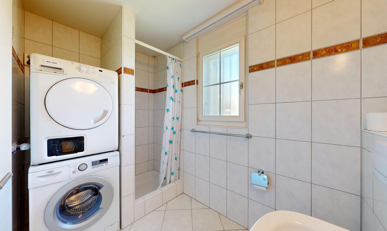buanderie avec buanderie, lave-linge et sèche-linge superposés, natural light, lumière naturelle, et inside property