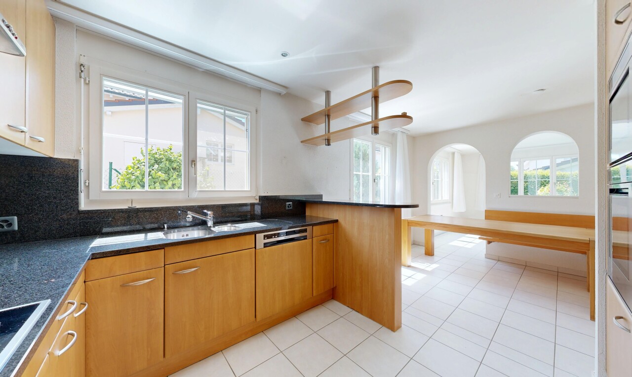 cuisine avec dark countertops, light floor, two heights countertops, medium brown cabinets, et armoires marron moyen