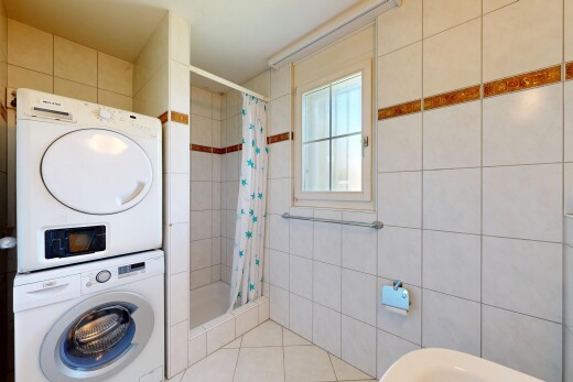 buanderie avec buanderie, lave-linge et sèche-linge superposés, natural light, lumière naturelle, et inside property