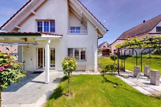 façade avec pelouse, terrasse, bardage en stuc, property visible, et clôture
