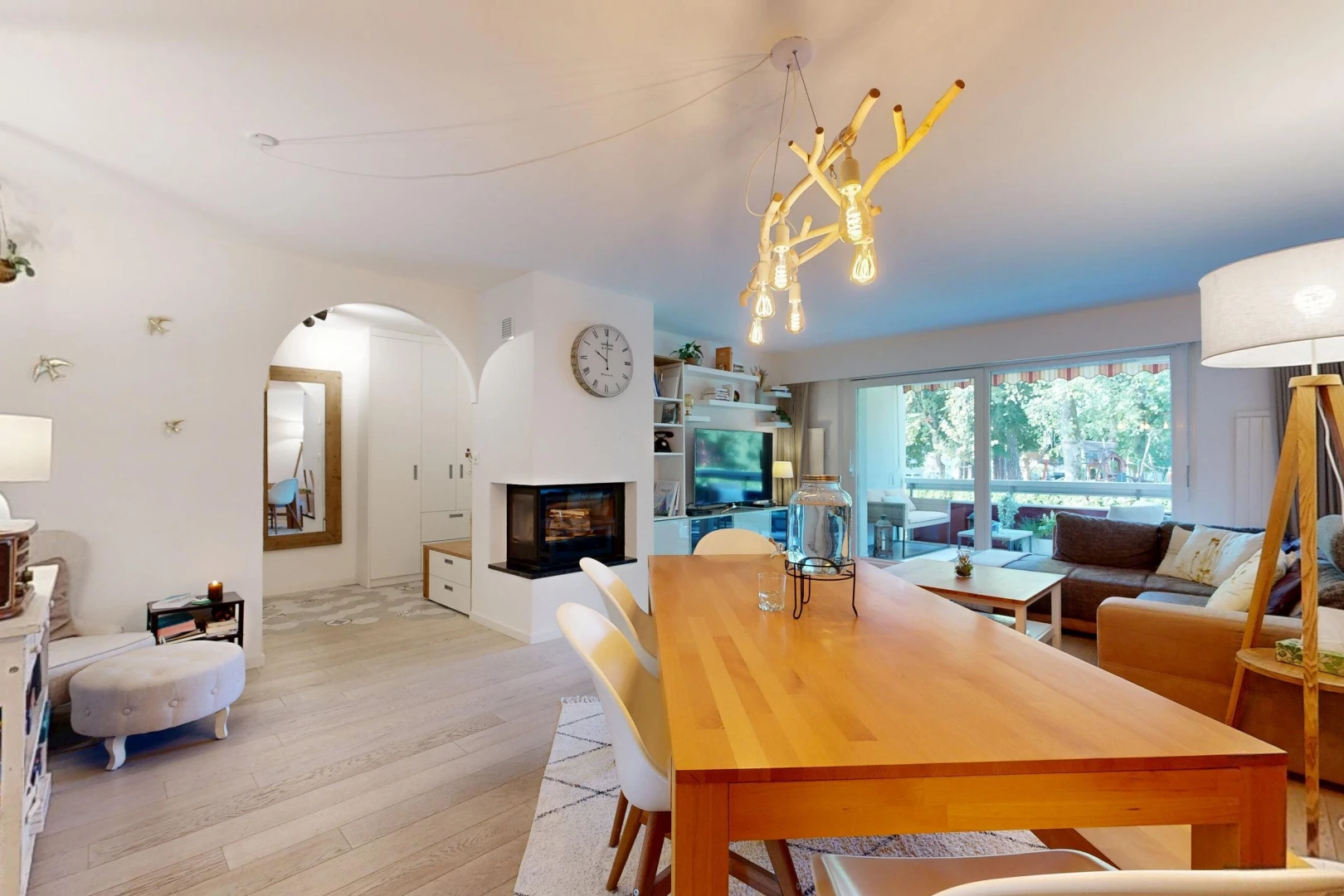 wohn- / esszimmer mit gewölbte gehwege, fernseher, wood finish floor, holzfußboden, und drywall