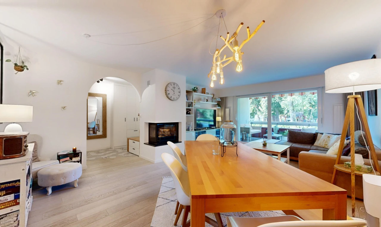 wohn- / esszimmer mit gewölbte gehwege, fernseher, wood finish floor, holzfußboden, und drywall