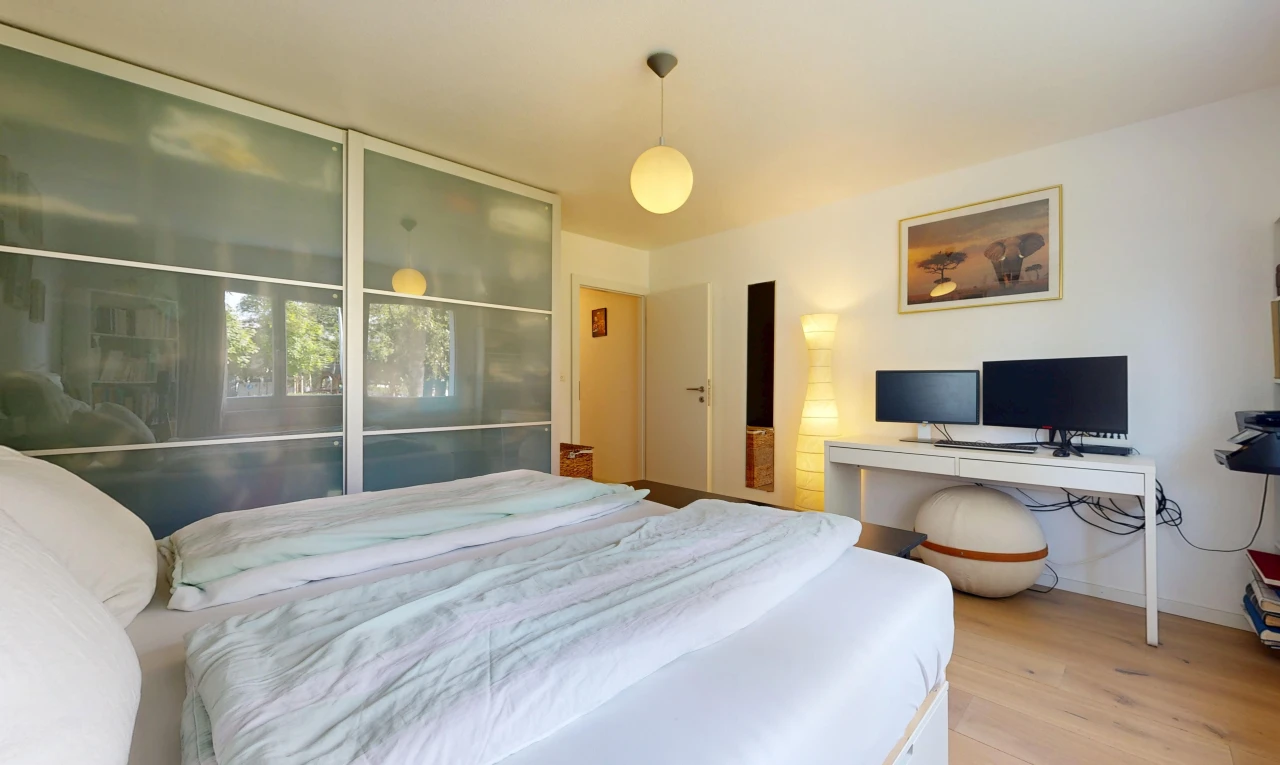 zimmer / schlafzimmer mit pendelleuchte, fernseher, drywall, gipskartonwand, und wood finish floor