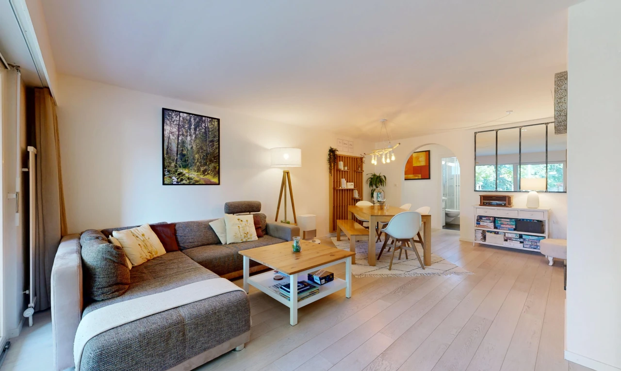 wohn- / esszimmer mit gewölbte gehwege, drywall, gipskartonwand, inside property, und wood finish floor