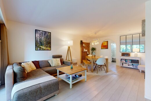 wohn- / esszimmer mit gewölbte gehwege, drywall, gipskartonwand, inside property, und wood finish floor