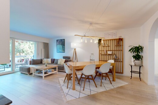 wohn- / esszimmer mit gewölbte gehwege, drywall, gipskartonwand, inside property, und wood finish floor