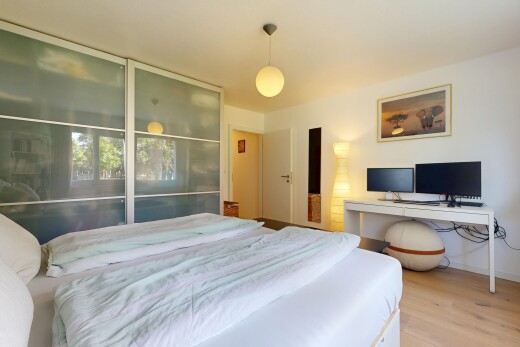 zimmer / schlafzimmer mit pendelleuchte, fernseher, drywall, gipskartonwand, und wood finish floor