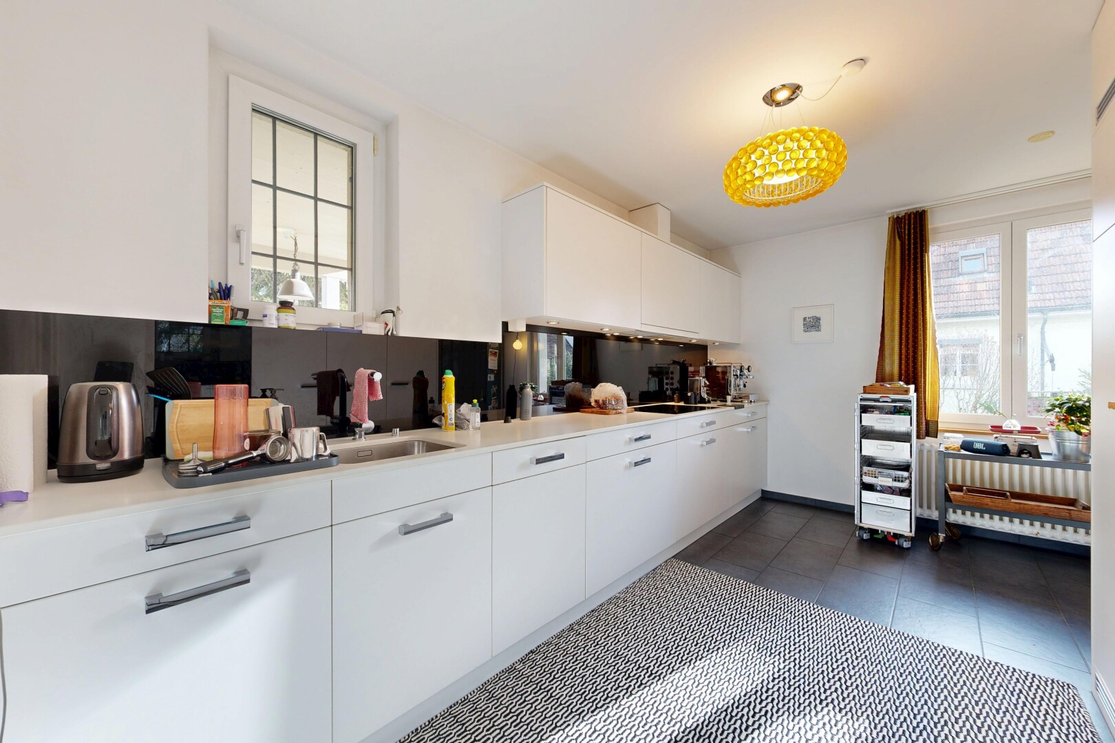cuisine avec armoires blanches, white cabinets, lumière naturelle, natural light, et dark floor