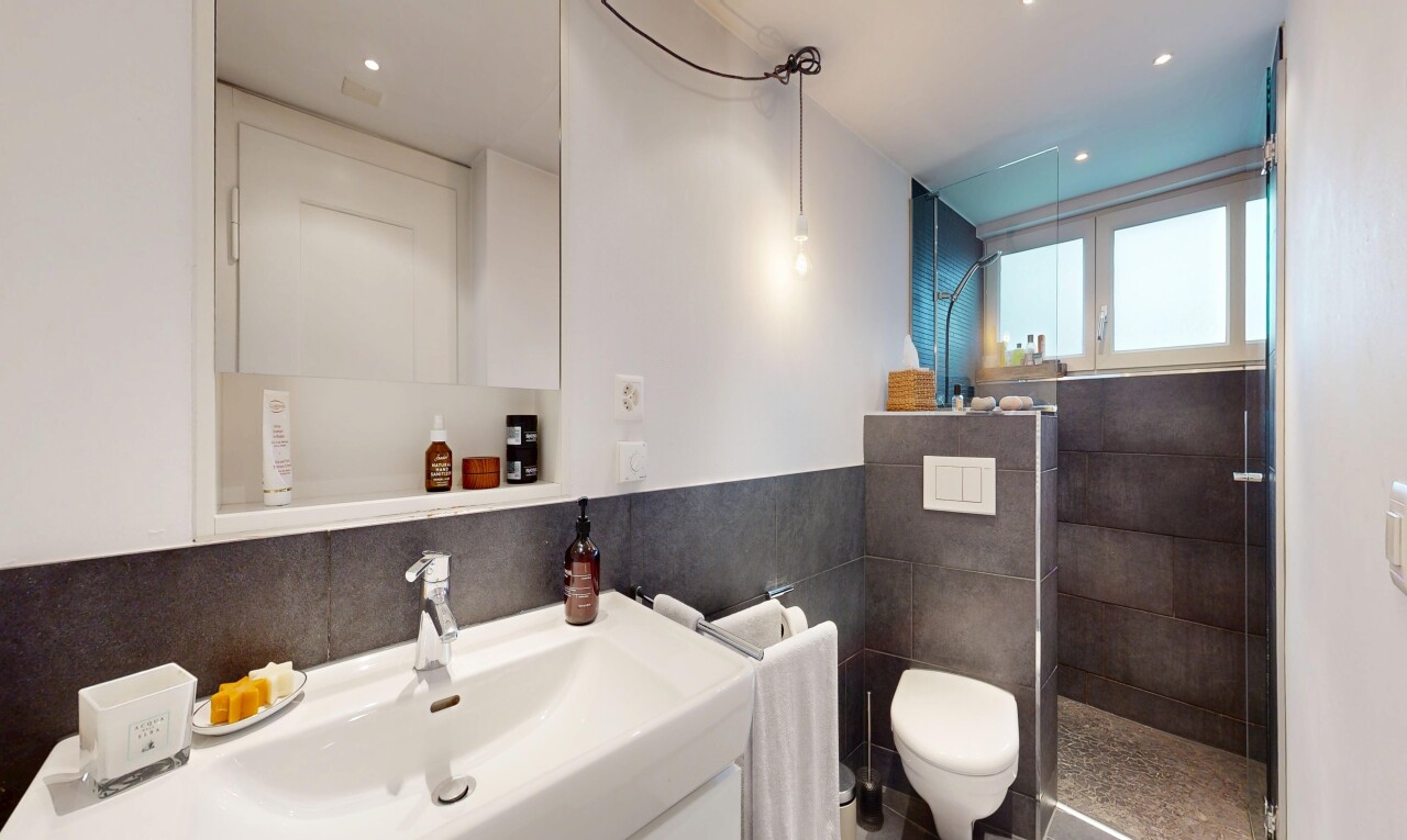 salle de bains avec miroir, lavabo (ou coiffeuse selon le contexte), douche, salle de bain complète, et inside property