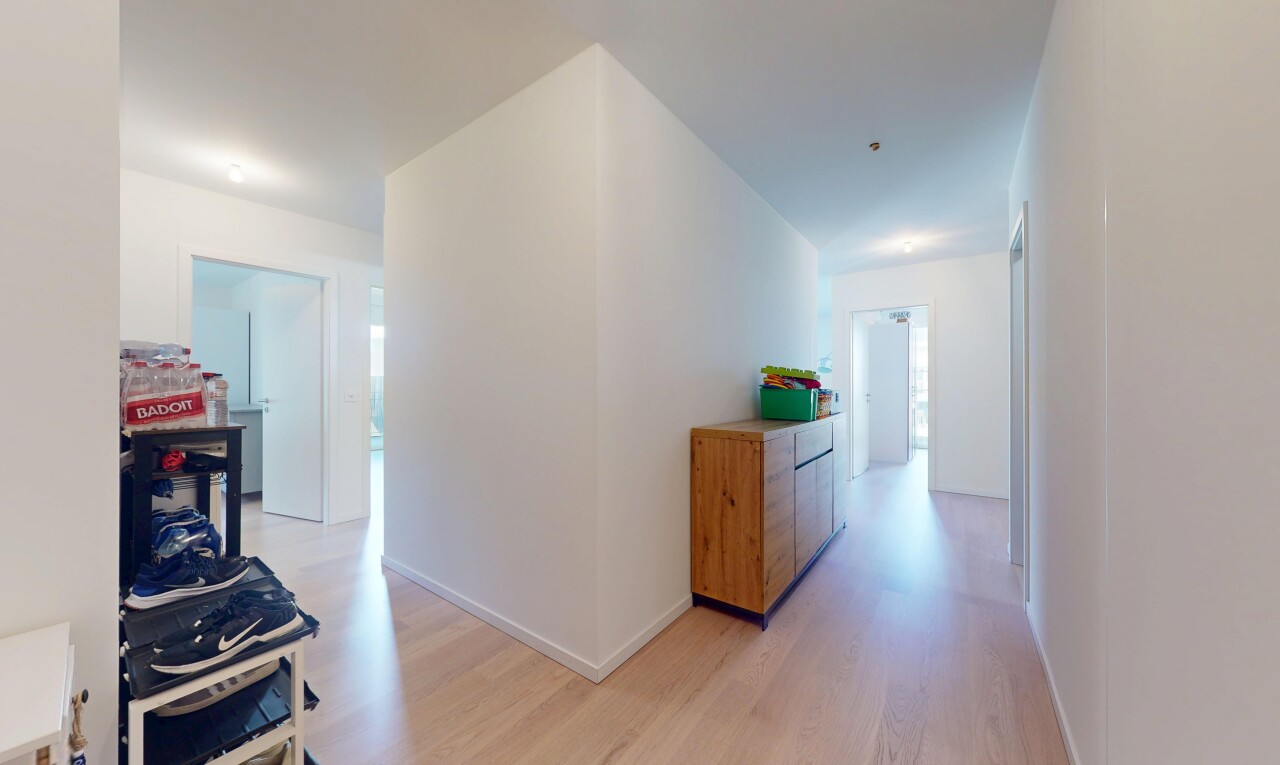 couloir avec sol en finition bois, wood finish floor, cloison sèche, drywall, et inside property
