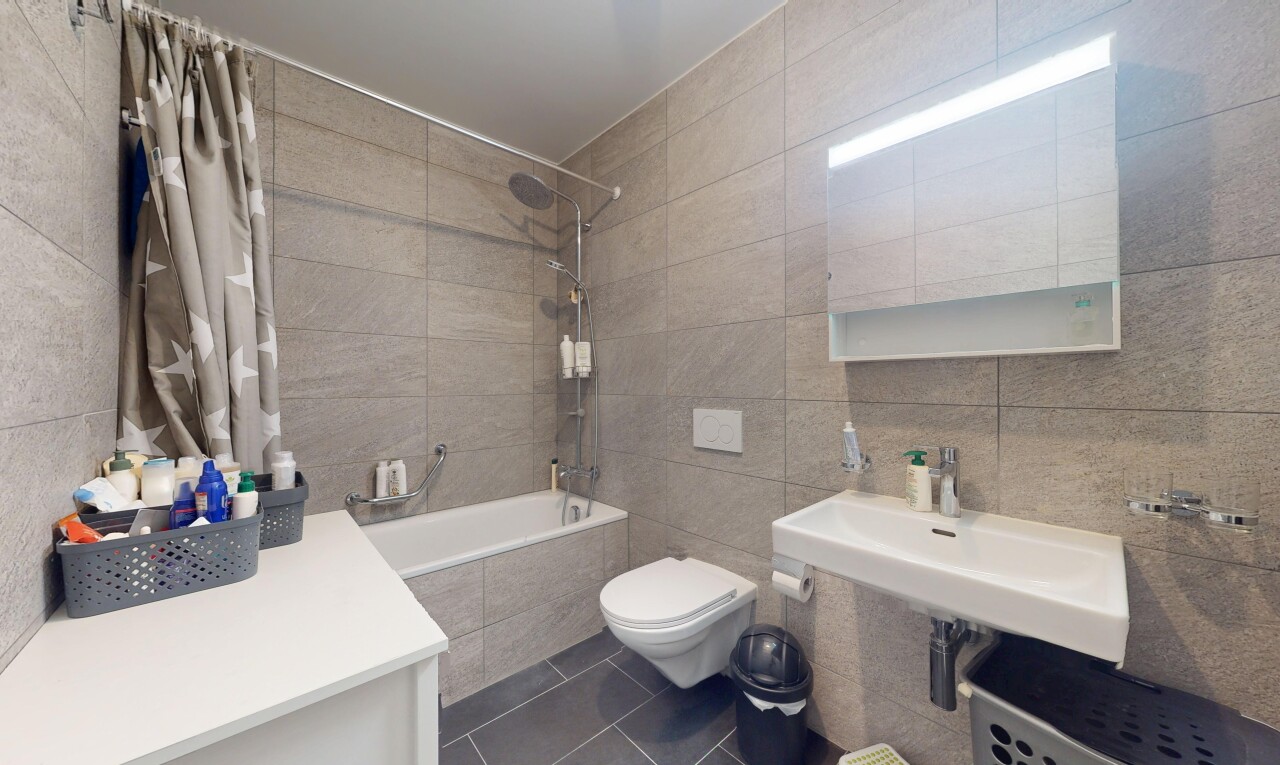 salle de bains avec mur en carrelage, tile wall, douche-bain combinés, sol en carrelage, et tile floor