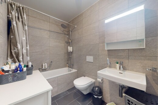 salle de bains avec mur en carrelage, tile wall, douche-bain combinés, sol en carrelage, et tile floor