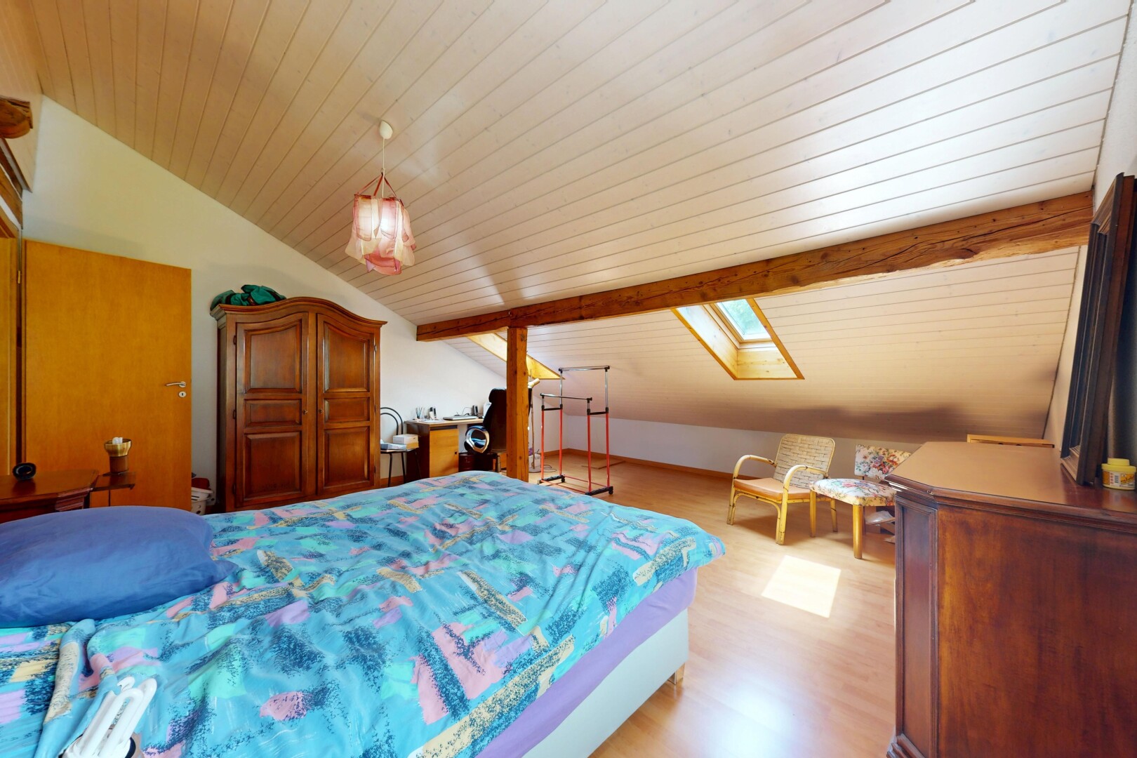chambre avec plafond voûté, vaulted ceiling, pièce supplémentaire, inside property, et sol en finition bois