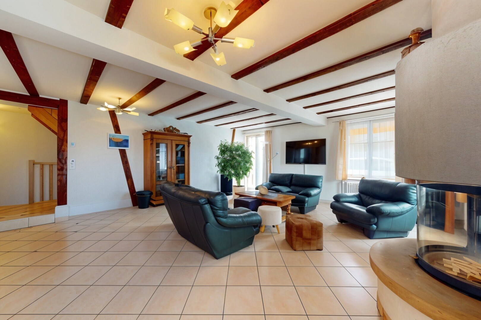salon avec télévision, plafond à poutres, beamed ceiling, lumière naturelle, et natural light