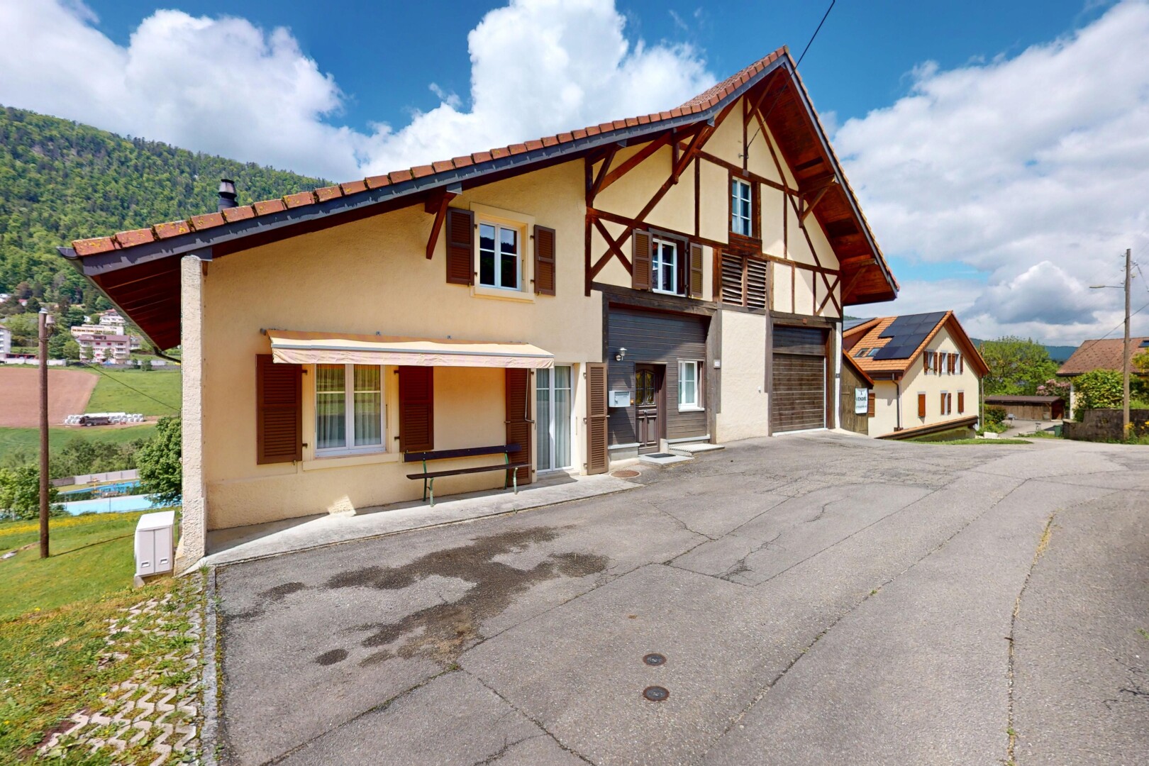 façade avec bardage en stuc, property visible, day time, allée, et garage