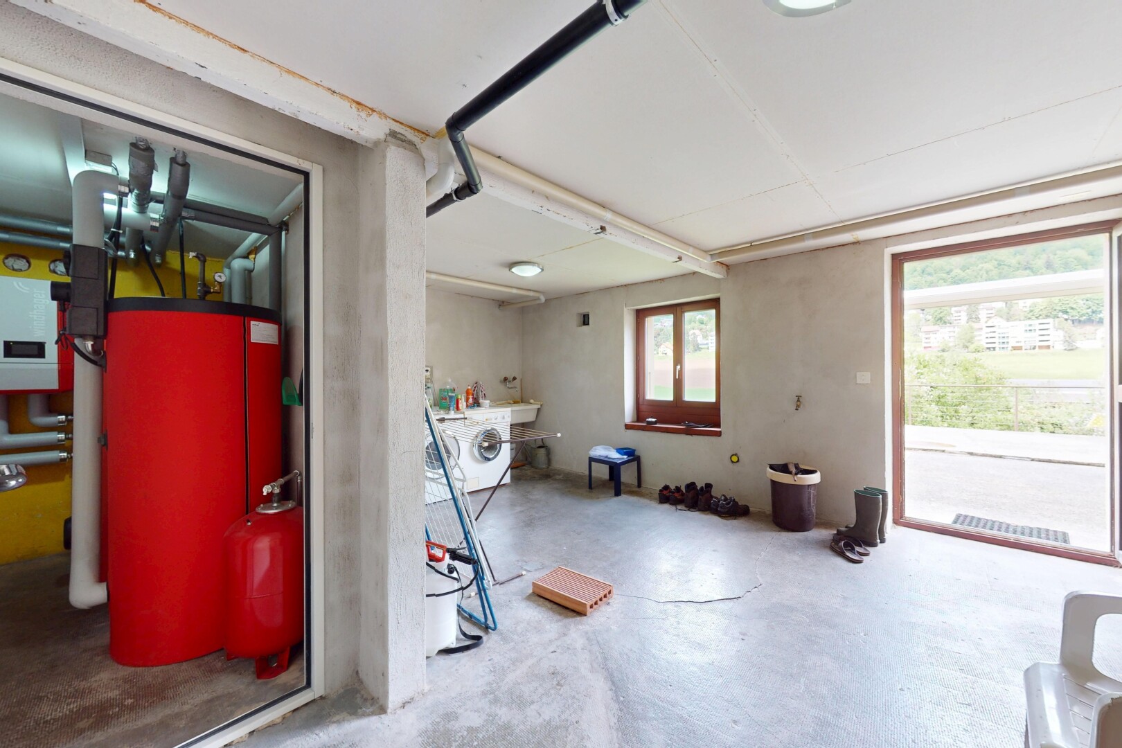 buanderie avec inside property, lumière naturelle, natural light, concrete floor, et lave-linge et sèche-linge