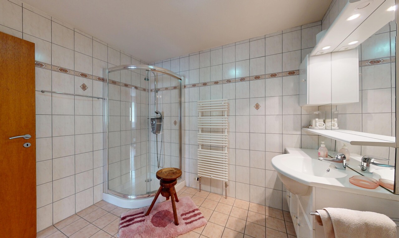salle de bains avec radiateur, mur en carrelage, tile wall, miroir, et inside property
