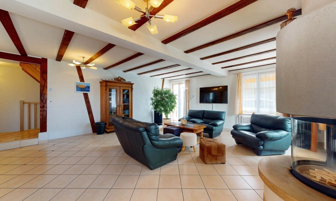 salon avec télévision, plafond à poutres, beamed ceiling, lumière naturelle, et natural light