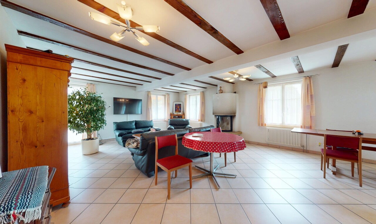 salon / salle à manger avec radiateur, télévision, plafond à poutres, beamed ceiling, et lustre remarquable