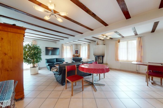 salon / salle à manger avec radiateur, télévision, plafond à poutres, beamed ceiling, et lustre remarquable