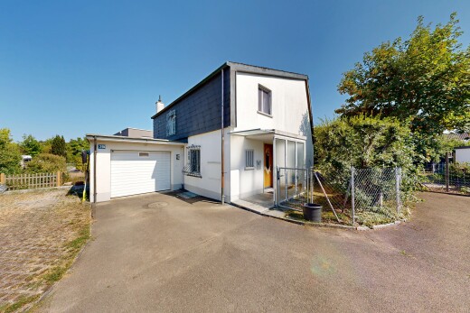 façade avec allée, property visible, clôture, garage attaché, et day time