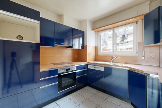 küche mit küchenrückwand beim herd, ofen, blaue schränke, natürliches licht, und arbeitsplatten